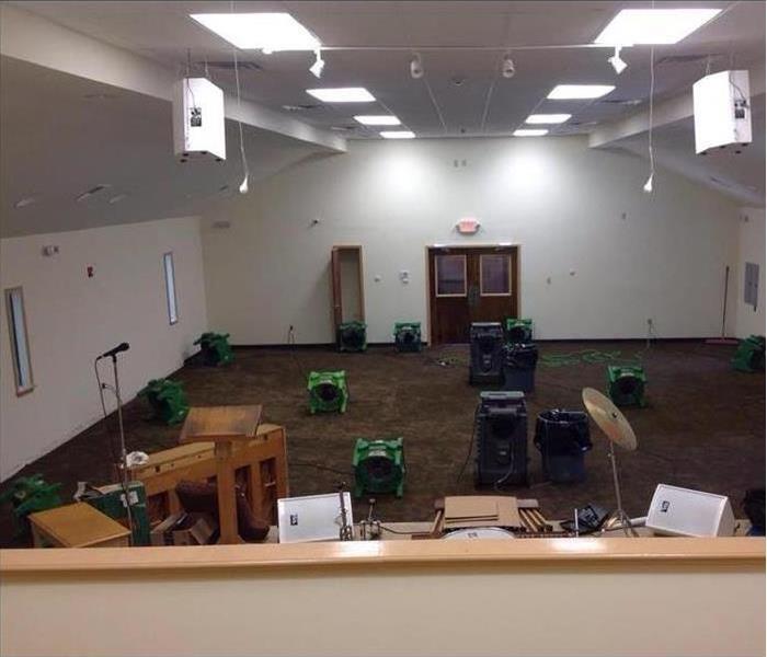 small room for church worship with SERVPRO air movers and HEPA filters on the carpeted floor